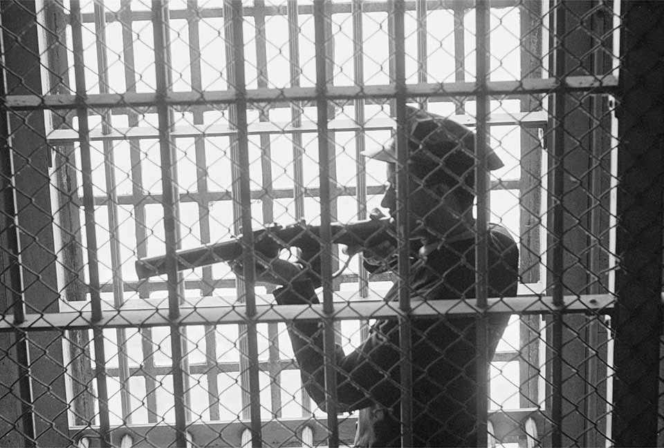 #13 Guard in D-Block Gun Gallery – A correctional officer poses with his weapon in the D-Block gun gallery.