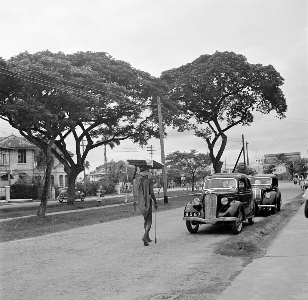 #122 A street view as a local man carries items on his head in Bridgetown, 1946