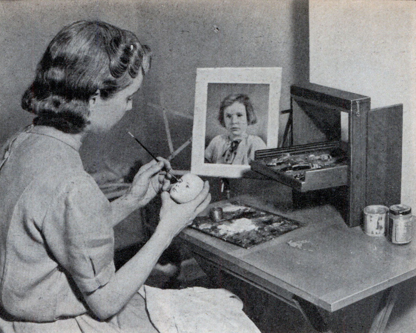 #1 Dewees Cochran painting eyebrows on a doll head modeled from a real child.