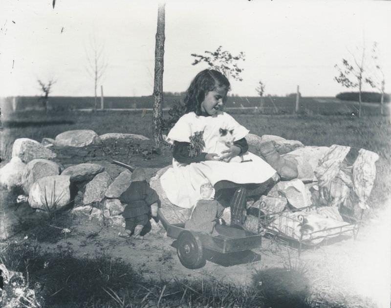 #1 Little girl playing with a kitten and dolls, 1900s