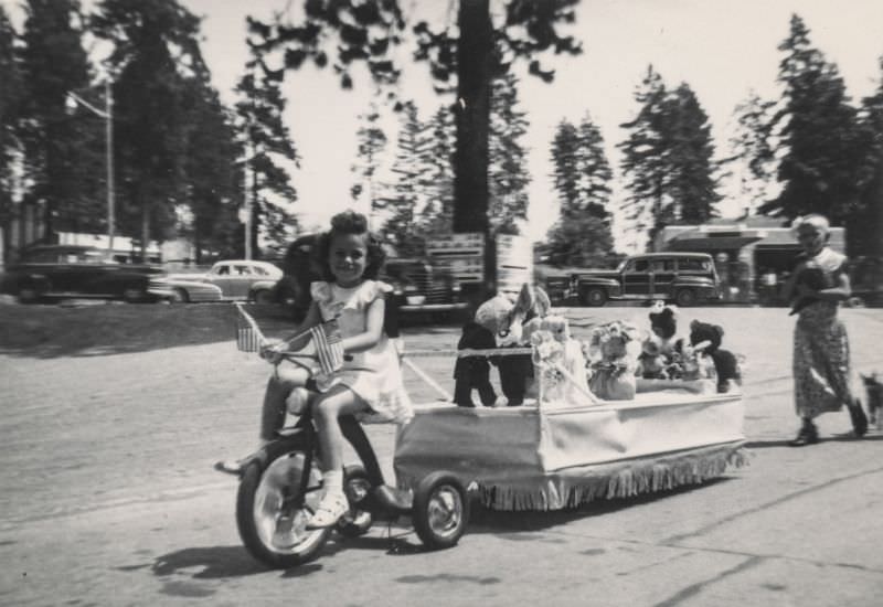 #18 Little girl pulling a parade float with her tricycle, 1940s
