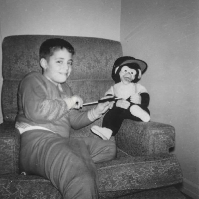 #23 Little boy playing with a stuffed monkey, late 1950s