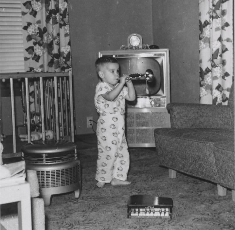 #24 Little boy playing a toy trumpet, September 1956