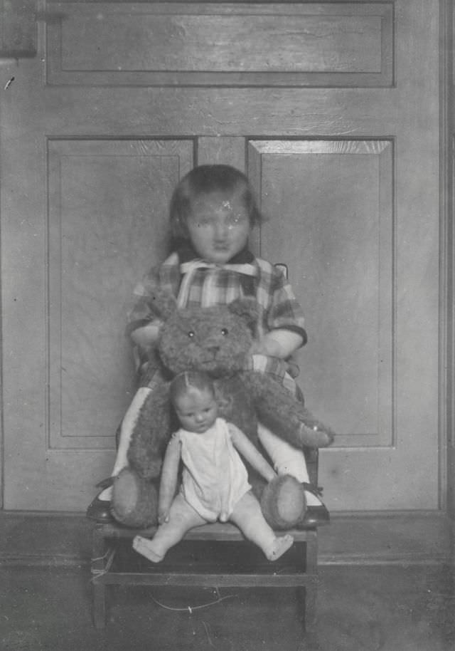 #27 Blurry-faced girl with her doll and stuffed bear