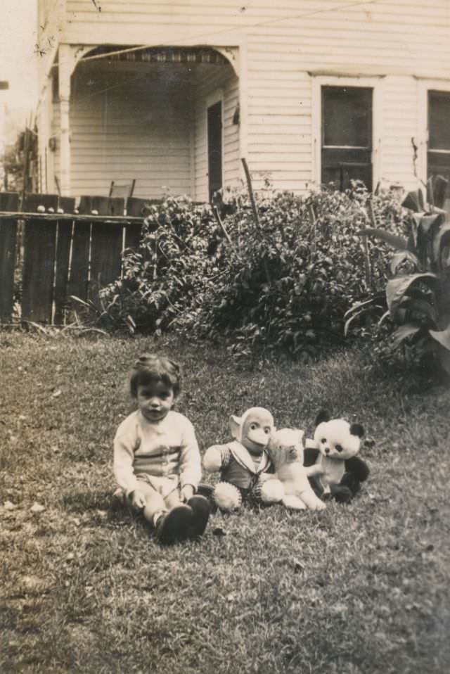 #30 Child sits in the back yard with stuffed animals