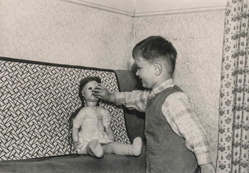 #34 Little boy feeding a doll