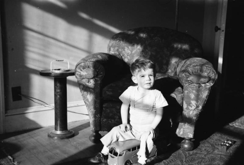 #37 Little boy plays with a cast iron toy bus