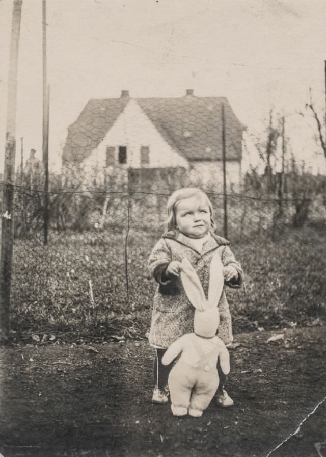 #42 Little girl playing with a stuffed rabbit in the garden