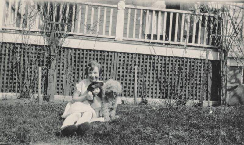 #9 Little girl sitting outside with her doll and dog, 1920s