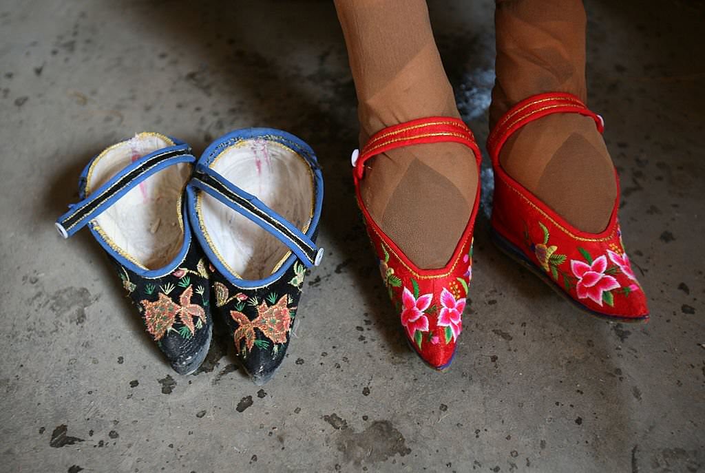 82-year-old bound feet woman Fu Jifen, displays “Three Cuns Golden Lotus” shoes she made at Liuyi Village on April 2, 2007.