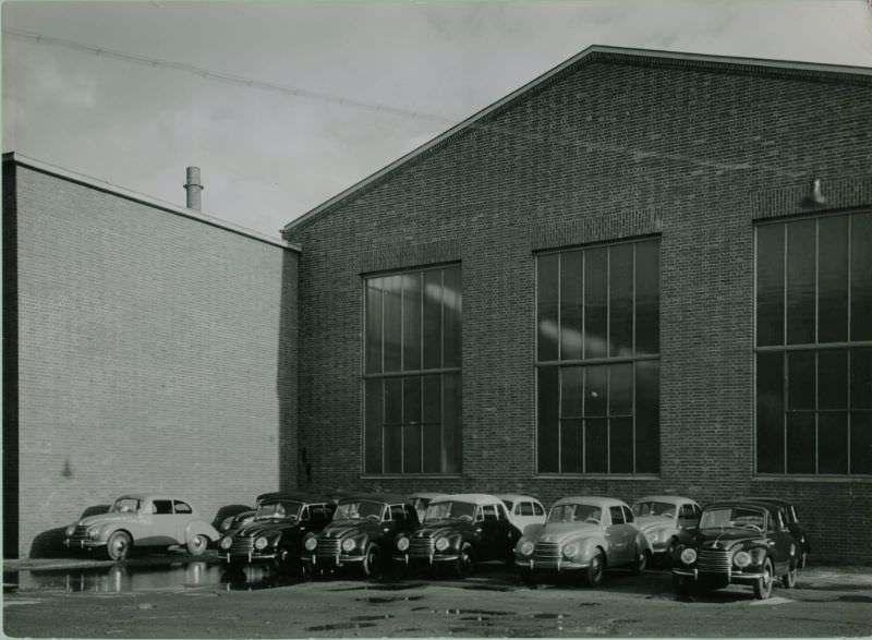 #12 Side of factory building with sedans and cabriolets, 1951