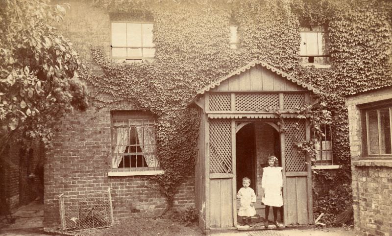 #15 Edwardian children stand in nicely made decorative timber porch