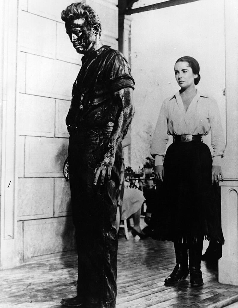 #3 Elizabeth Taylor gazes at a begrimed James Dean (1931-1955) in a scene from the film ‘Giant