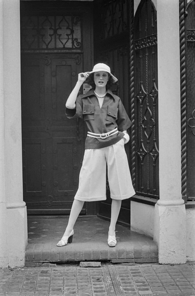 #13 Fashion model Ika wearing knee-length culottes and a wide-brimmed hat, UK, 5th April 1974.