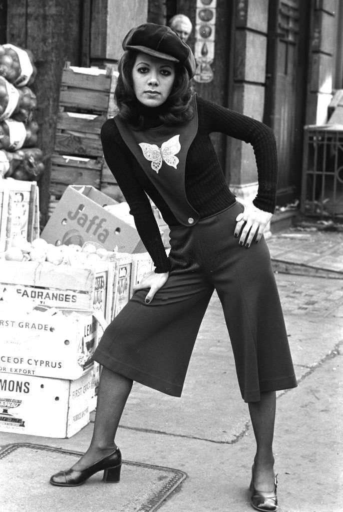 #23 A young woman wearing culottes attached to a tabard-style top with a butterfly motif, in London’s East End, 1970