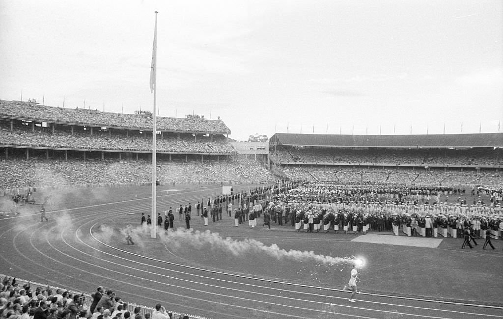 #28 Wide view of Australia Ron Clarke with Olympic torch at Melbourne Cricket Ground Stadium. Melbourne, 1956