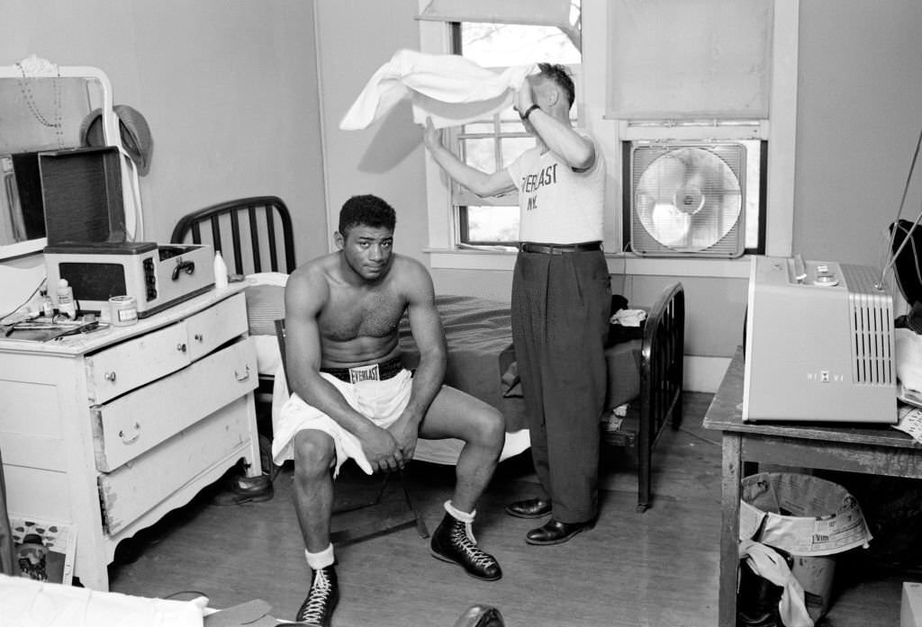 #33 Floyd Patterson being fanned with a towel in his room at Ehsan’s training camp, 1959