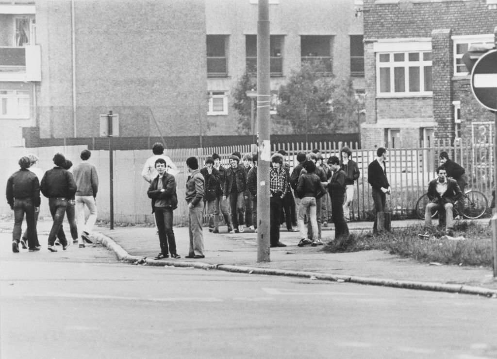 #79 A crowd of youths standing on a street corner before rioting started in the Toxteth area of Liverpool, England, July 1981.