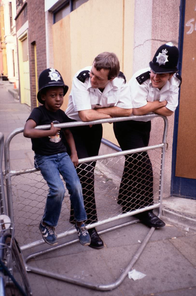 #58 Police with young child in Toxteth, 1981