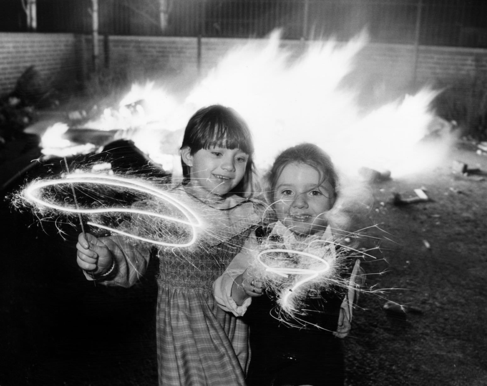 #61 Clare aged 6 and Lindsay Gerard aged four (right) enjoying their sparklers at an impromptu bonfire party in Kensington, Liverpool, 1986