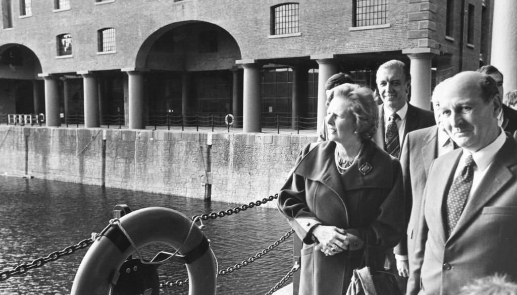 #83 British Prime Minister Margaret Thatcher accompanied by Sir Leslie Young, observes the architecture of Albert Dock during her visit to the city of Liverpool, 3rd October 1984.