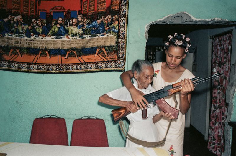 #29 Milena Montano helps her great aunt, La Conchita, pose with the AK47, Managua, Nicaragua, 1985
