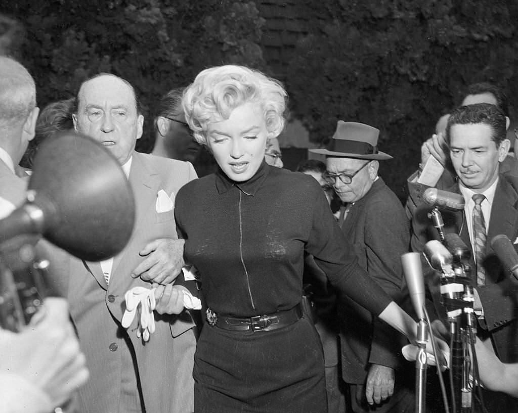 #8 Monroe outside her home with lawyer Jerry Giesler, who later that day would announce that Monroe’s marriage to Joe DiMaggio was ending.
