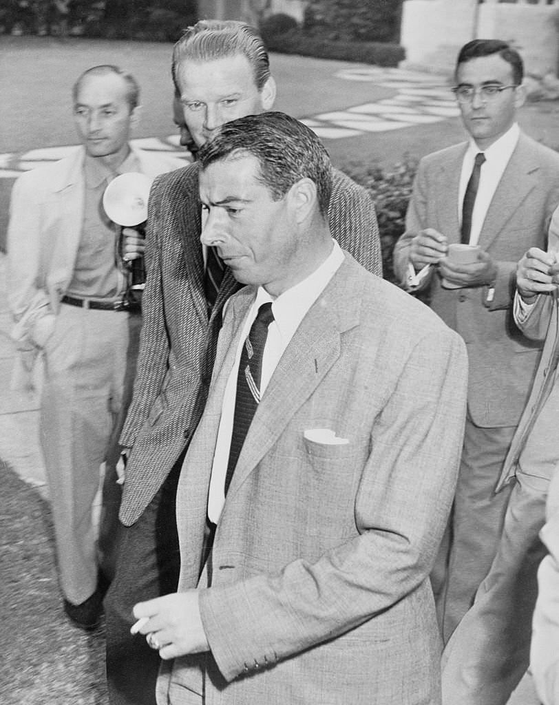 #11 Joe DiMaggio strides past newsmen as he leaves the Beverly Hills honeymoon home he shared with film star Marilyn Monroe.