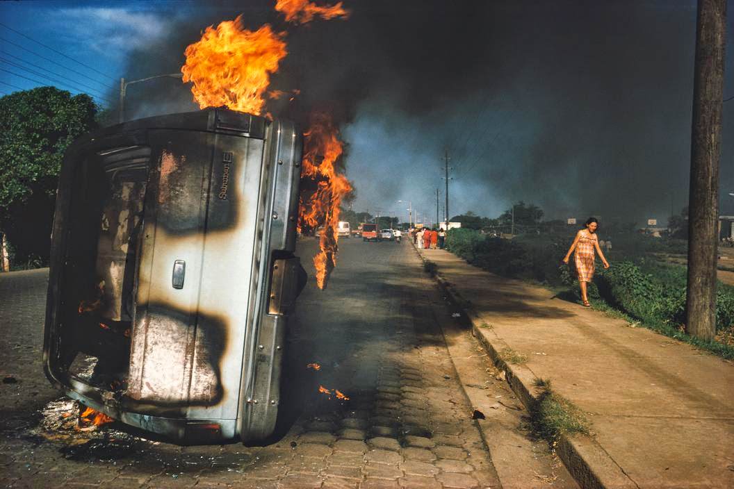 #57 Car of a Somoza informer burning in Managua, Managua, 1970s
