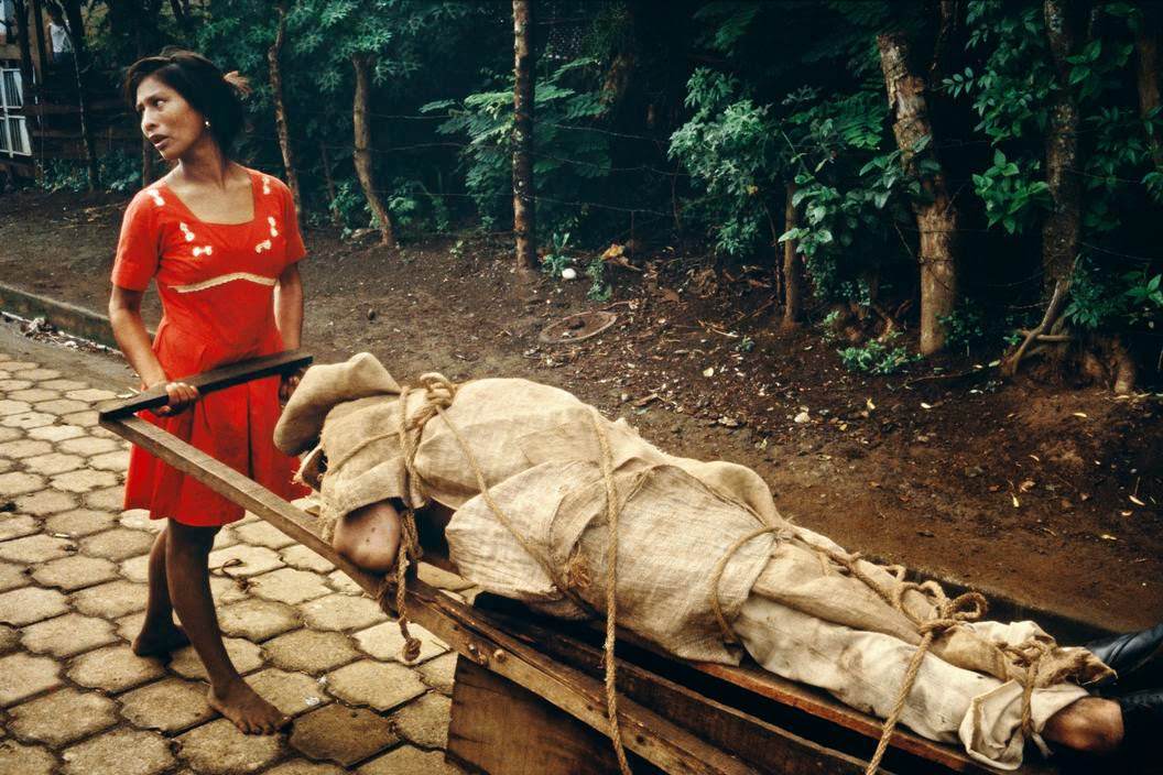 #63 Monimbo woman carrying her dead husband home to be buried in their backyard, Monibo, 1979