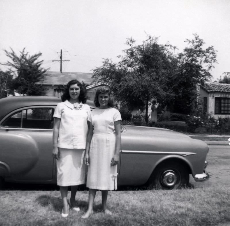 #23 Two young women in white – probably dressed for a special occasion – posing with a 1951-52 Packard 200 Sedan.
