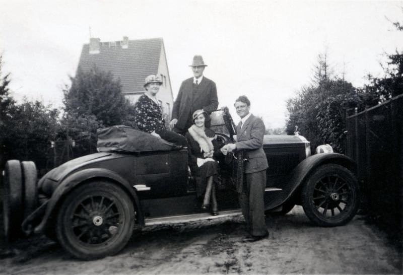 #5 Two elegant couples posing with a 1926 Packard Roadster open-topped in a residential street on the outskirts of town, 1928