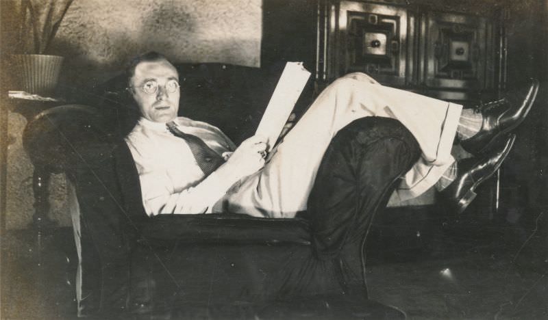 #13 Man reads while laying on a chair, circa 1930s