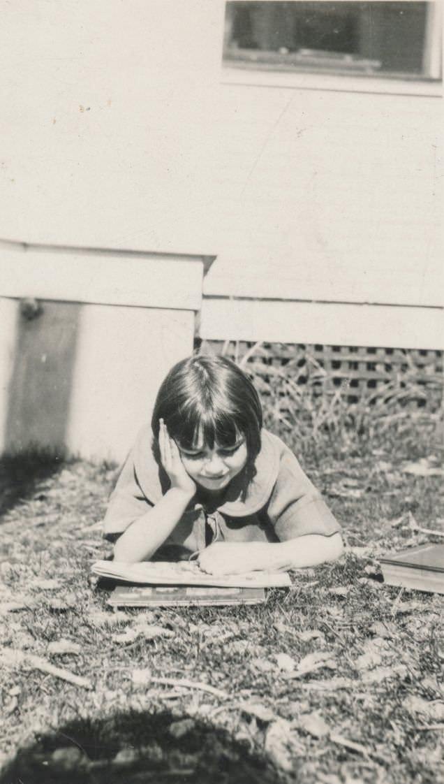 #25 Little girl reading a book outside