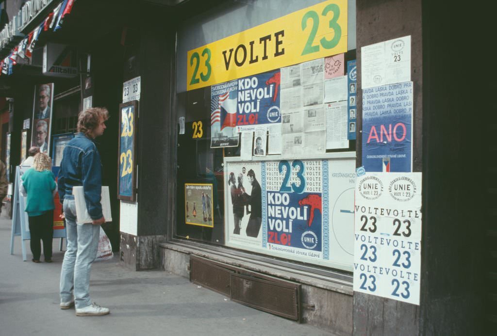 #37 A man watches billboards for a political campaign, Prague, Czech Republic, June 1990.