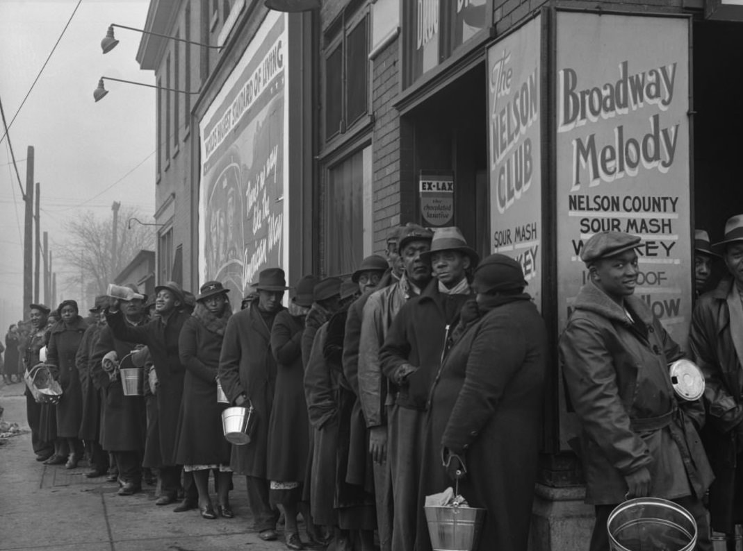 #8 African Americans in Louisville, Kentucky, seek food and clothing from a relief station in the aftermath of flooding that devastated the city in 1937.