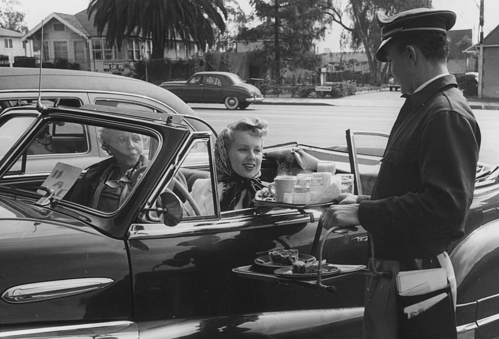 #16 To Go.A waiter serves food to motorists at a drive-in restaurant in the Hollywood district of Los Angeles, 1951