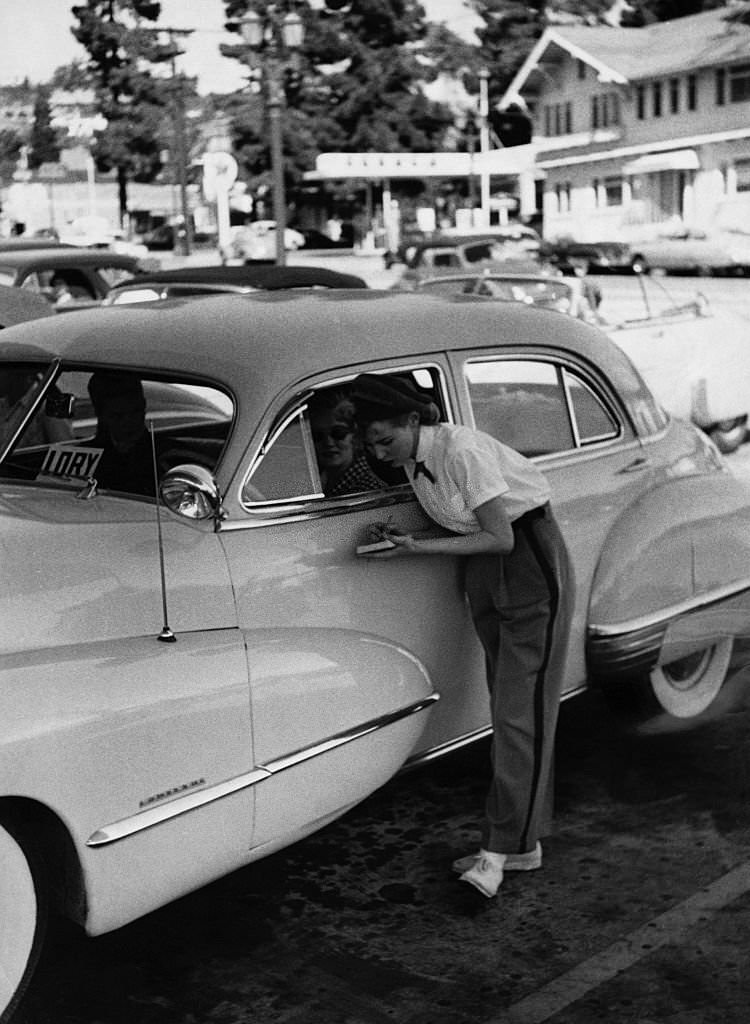 #19 A young waitress notes down a motorist’s oder at a drive-in restaurant in Hollywood.