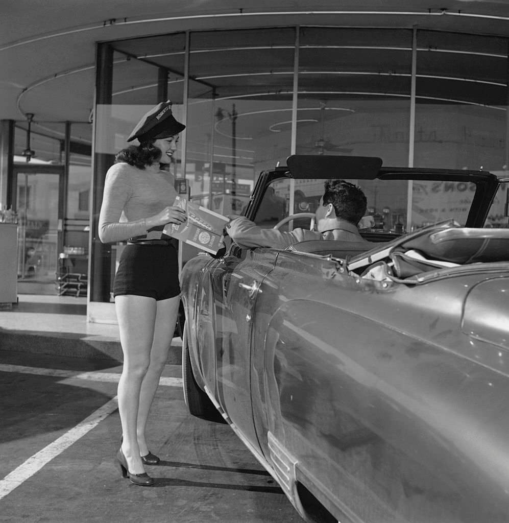 #33 A waitress in shorts takes an order from a customer at a Roberts Brothers drive-in restaurant, 1958.