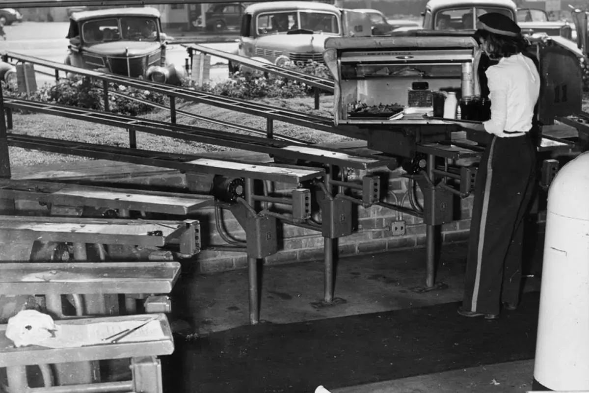 #58 An employee loads the conveyor belts with meals for hungry customers.