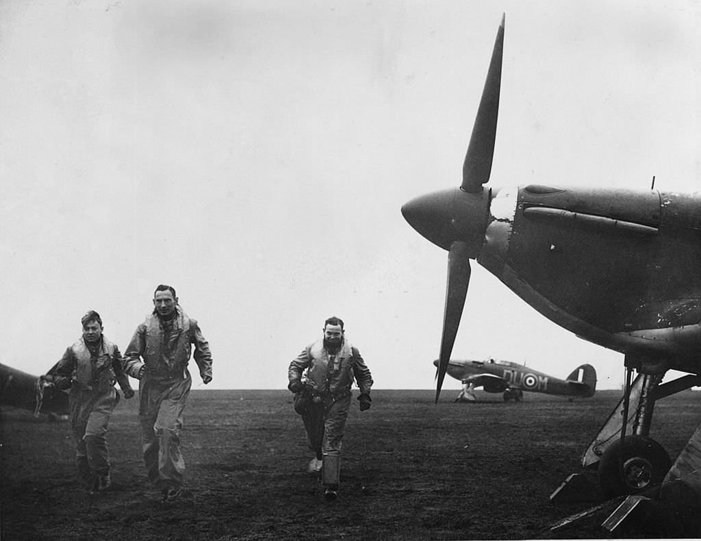 #23 Czechoslovakian pilots running to their Hurricane fighter planes on an airfield ‘somewhere’ in the north of England after receiving an alert.