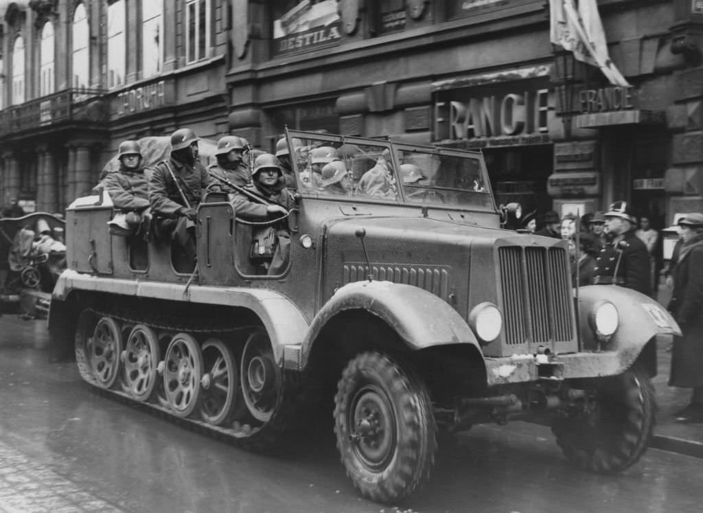 #53 German troops enter Prague in Czechoslovakia, at the beginning of the German occupation, 1939. On the right is a Czech police officer.