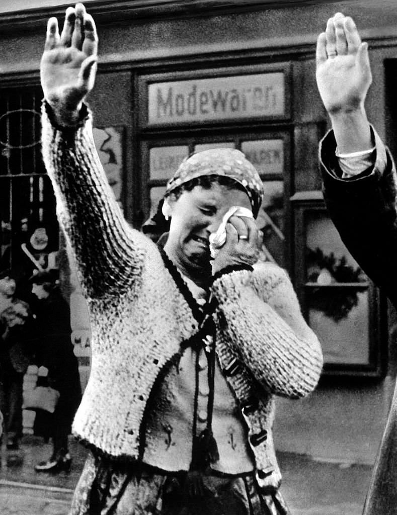 #56 A woman in the Sudetenland greets incoming German troops with tears and a German Salute.