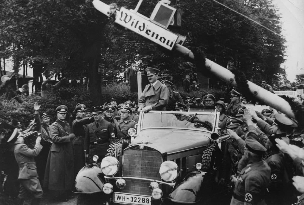#68 Adolf Hitler stands up in his car to acknowledge his welcome as he crosses the frontier into Sudetenland.