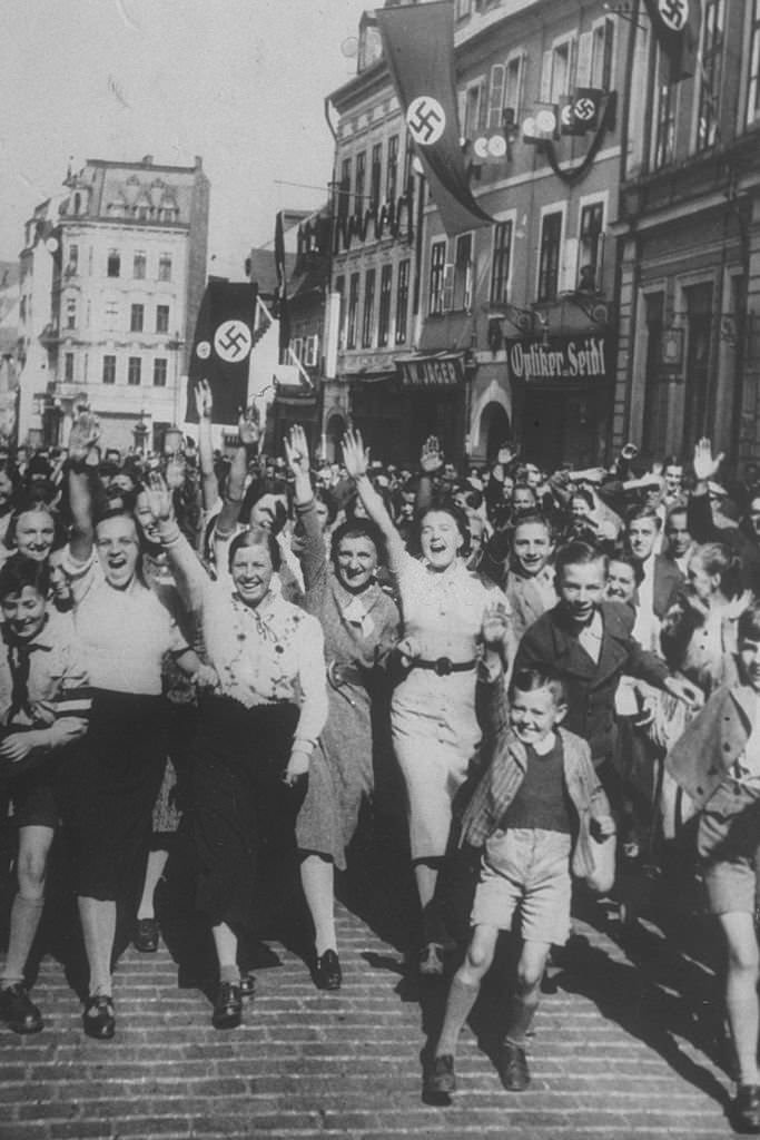 #82 Women and young boys celebrating the German occupation of Asch, home of Konrad Henlein, leader of the Sudeten German party.