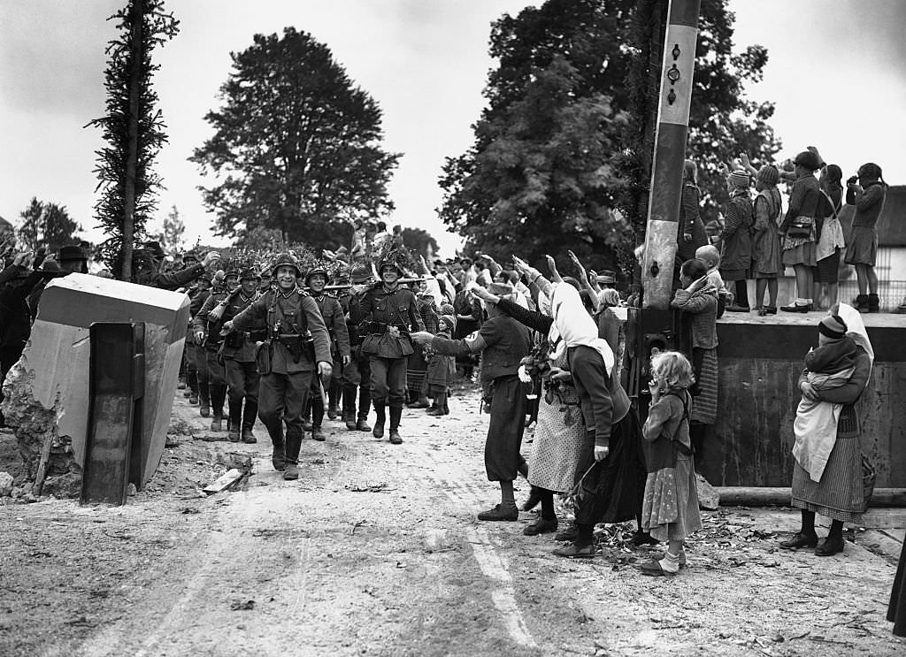 #83 Peasants give German soldiers the Hitler salute as they cross the Czechoslovakian border
