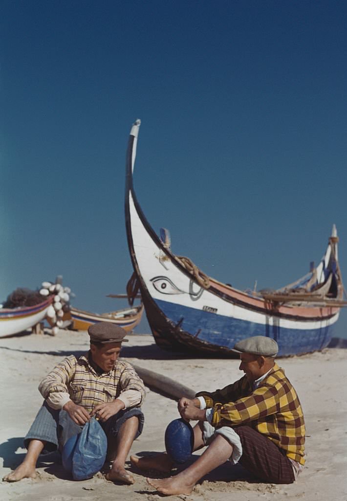 #8 Portuguese fishermen prepare their nets on the beach at Nazare, Portugal, 1955.