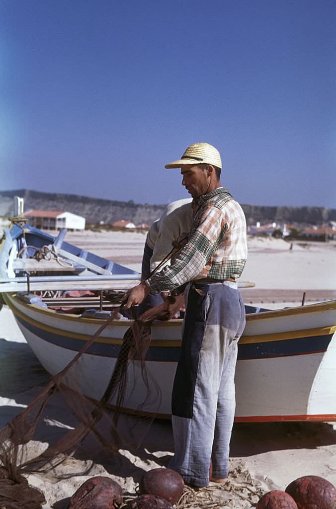 #9 Portuguese fishermen prepare their nets on the beach at Nazare, 1955.