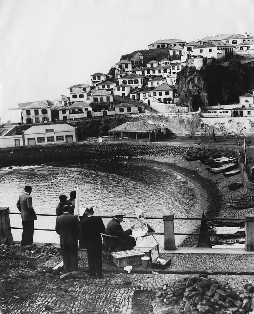 #15 British statesman Winston Churchill (1874 – 1965) paints the fishing village of Camara de Lobos, during a holiday in Madeira, 9th January 1950.