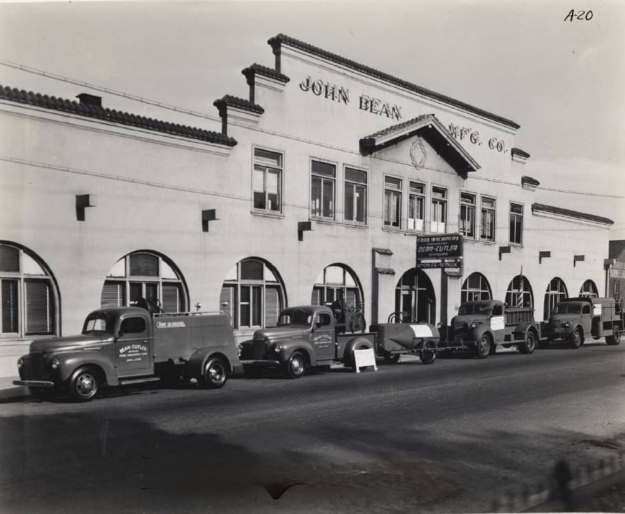 #82 John Bean Manufacturing Co. building. Fleet of trucks parked along street, 1940s